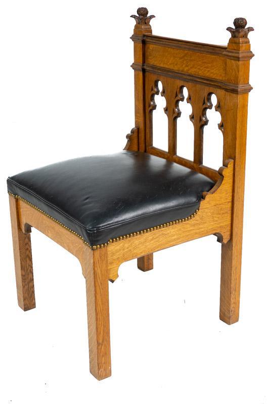 Gothic-Style Castle Chair: Gothic-style castle chair, faux leather seat, stud accents, carved back 40" tall x 22" wide x 21" deep State-wide delivery is available for this item. Please email shipping@vogtauction.com or call 210