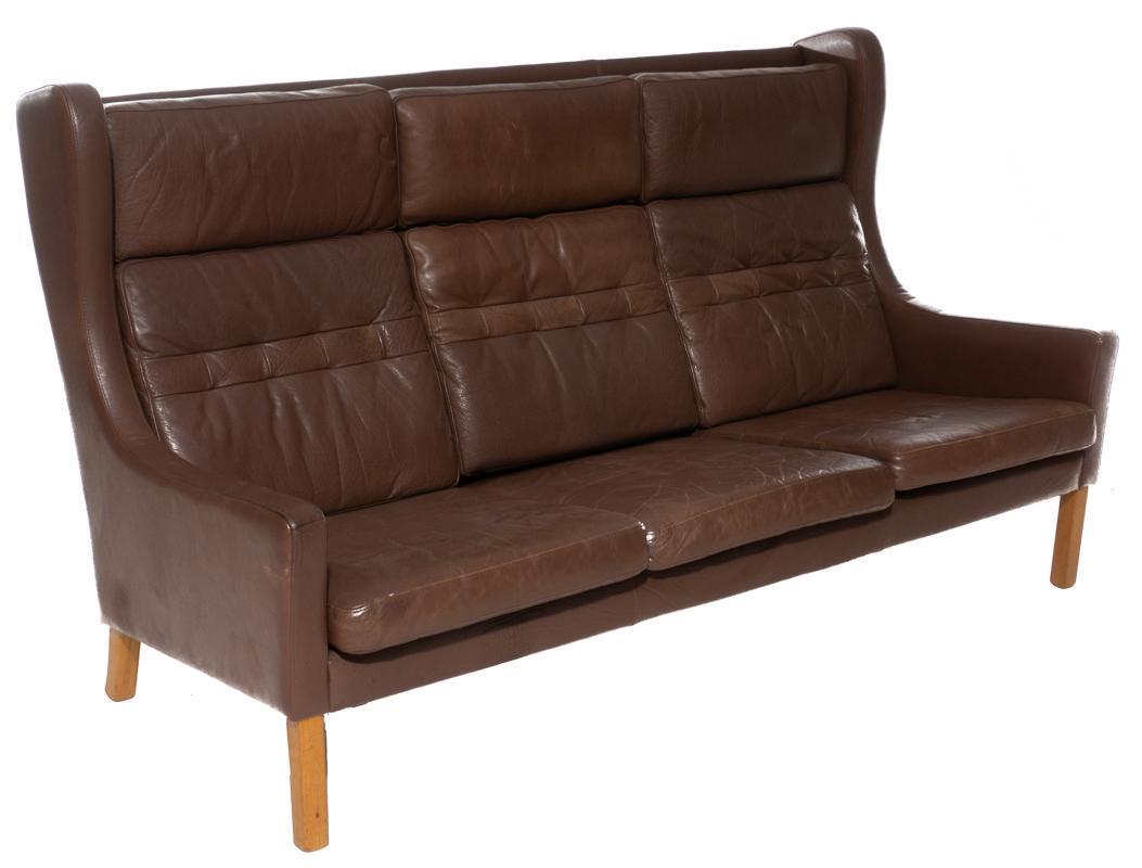 Danish Mid-Century Leather Sofa: Danish Mid-Century leather sofa, 3-seat, wooden legs, wing button back 38.5" tall x 68.5" wide x 33.56" deep State-wide delivery is available for this item. Please email shipping@vogtauction.com or ca