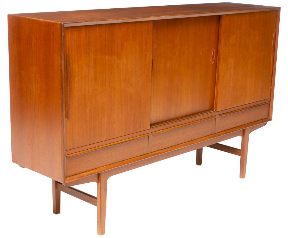 Danish Mid-Century Teak Sideboard: Danish Mid-Century teak sideboard, 3-sliding doors open to fitted and mirrored interior, stretchered pin legs, 3-drawers 43.5" tall x 69" wide x 17" deep State-wide delivery is available for this item