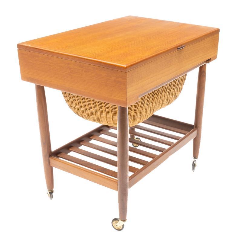 Danish Mid-Century Sewing Table: Danish Mid-Century sewing table, on castors, wicker basket, hinged top opens to shelved interior 23" tall x 23.5" wide x 16" deep State-wide delivery is available for this item. Please email shipping@