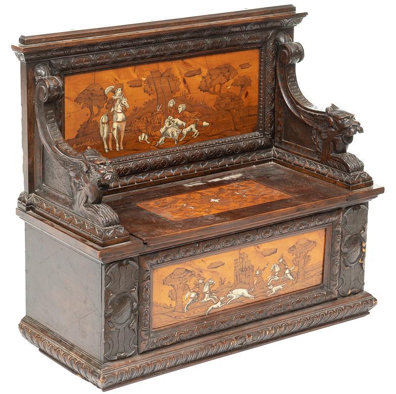 19th c. Carved Hunting-Style Bench: 19th c. hunting-style bench, bone inlaid figural hunting scenes, hinged seat opens to storage compartment, carved beast arms 37.5"h x 42.5"w x 18.5"d Condition: Losses to inlay State-wide delivery is 
