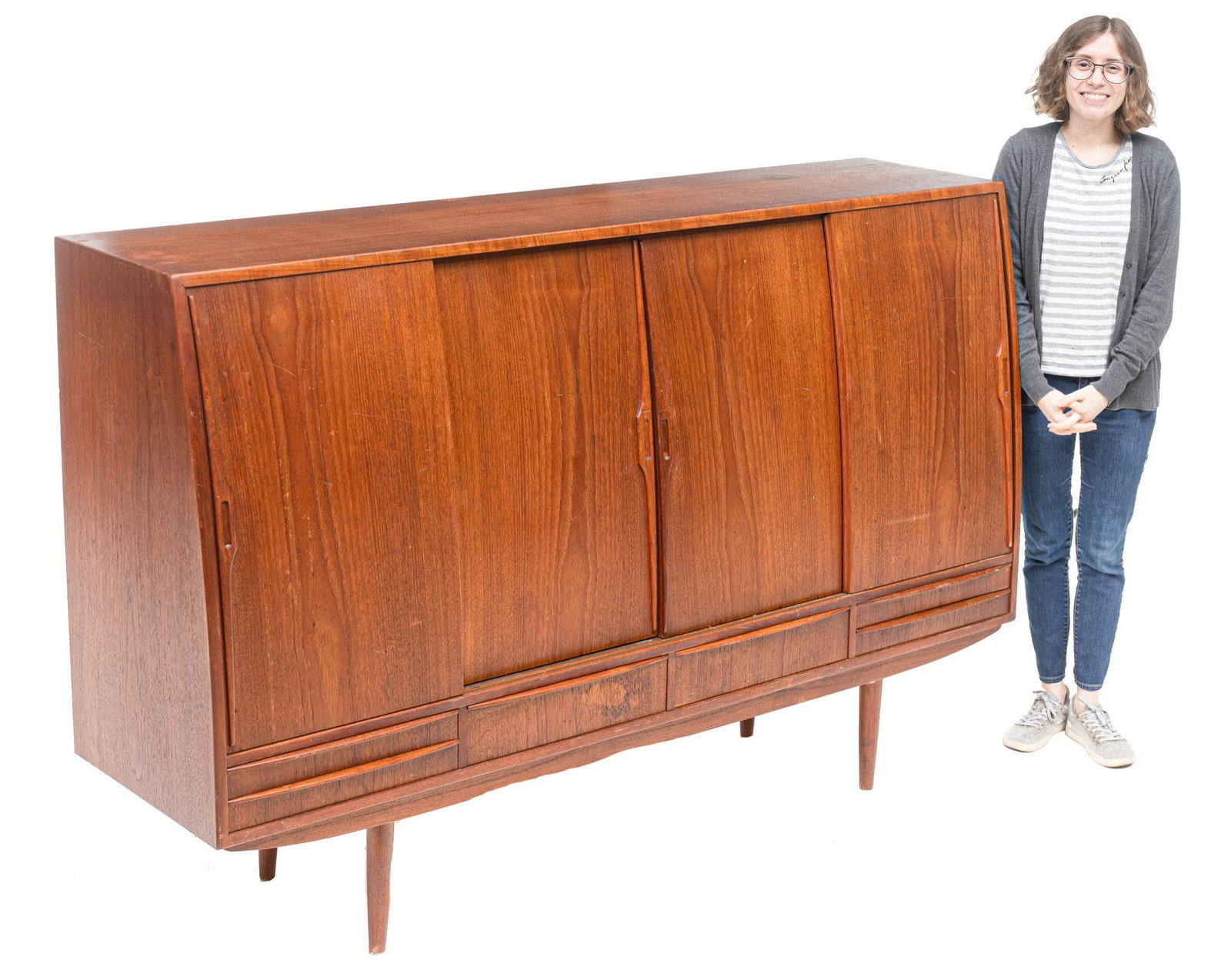 Danish Mid-Century Sideboard: Danish Mid-Century sideboard, four sliding doors open to mirrored and shelved interior, above six drawers, rising on pin legs 48"h x 72"w x 19"d Condition: One break to glass We happily provide seamle