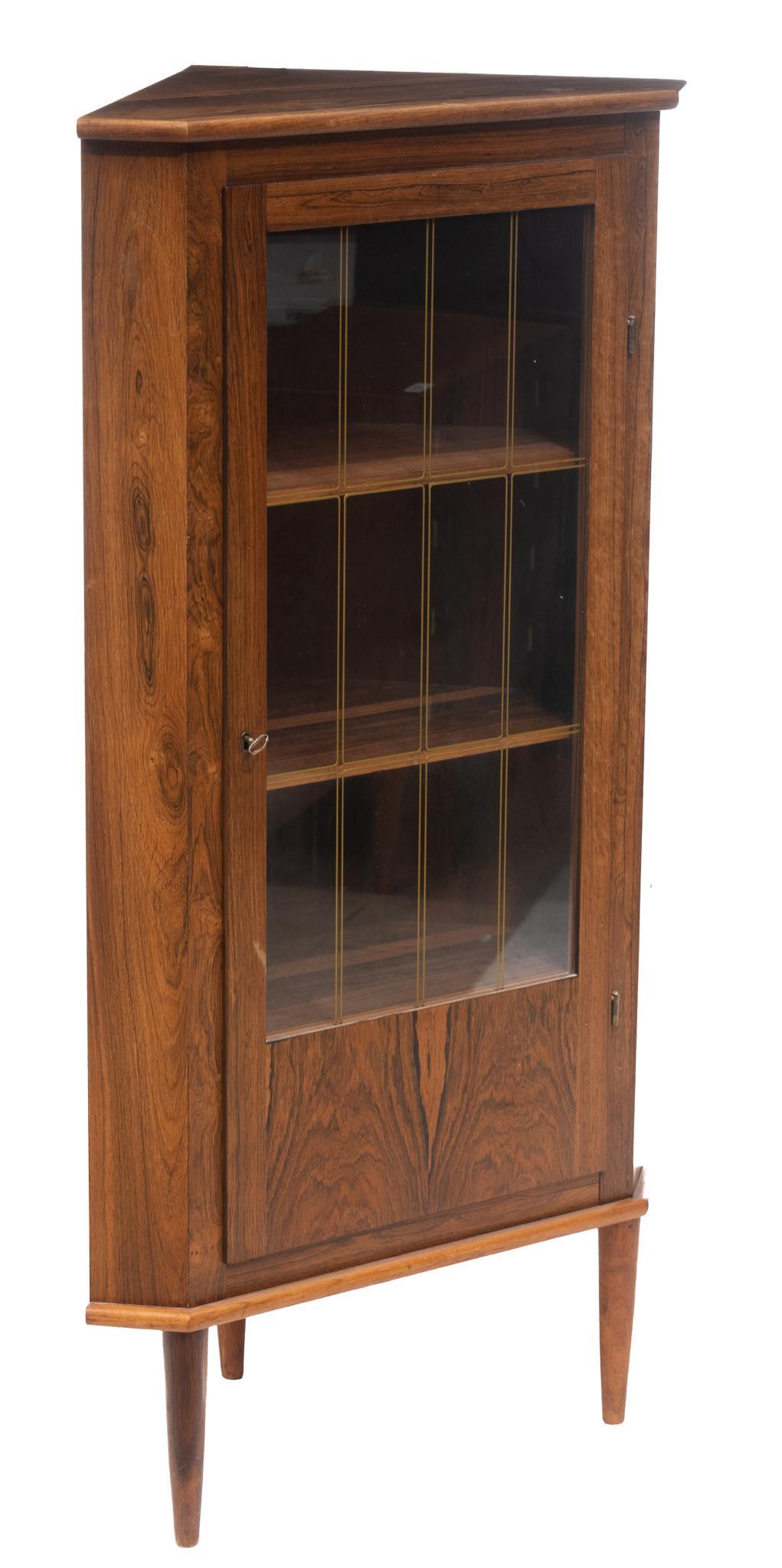 Danish Mid-Century Glazed Corner Cabinet: Danish Mid-Century corner cabinet, single glazed door opens to shelved interior, includes key, rising on pin legs 56"h x 29"w x 20"d We happily provide seamless shipping services on everything we se