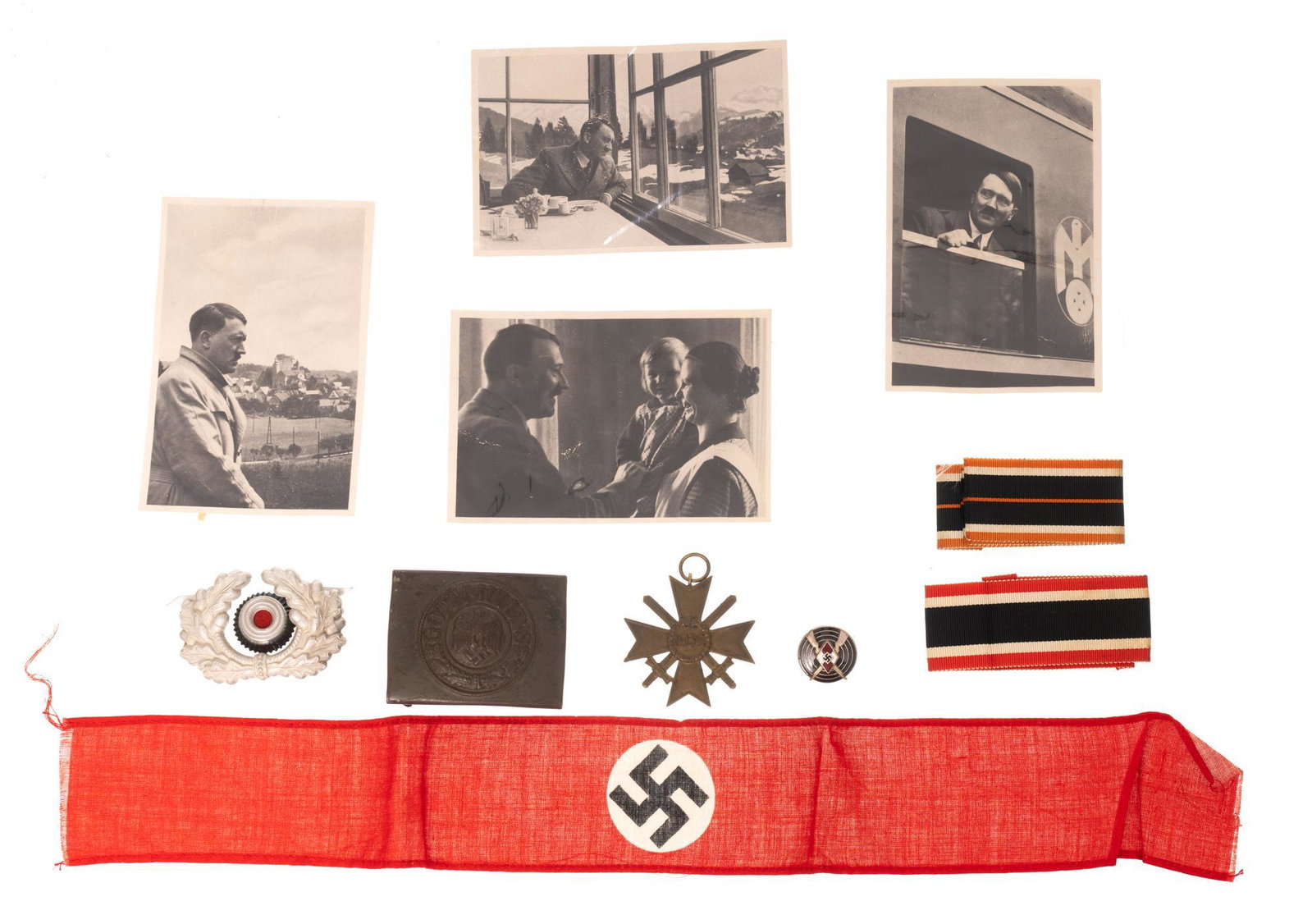 Lot of Nazi Germany Ephemera: Includes: Swastika arm band; belt buckle; visor cap badge; 1939 merit cross medal; 2 medal ribbons; pin; 4 photographs of Adolf Hitler Condition: all are commensurate with age Provenance: A San Antoni