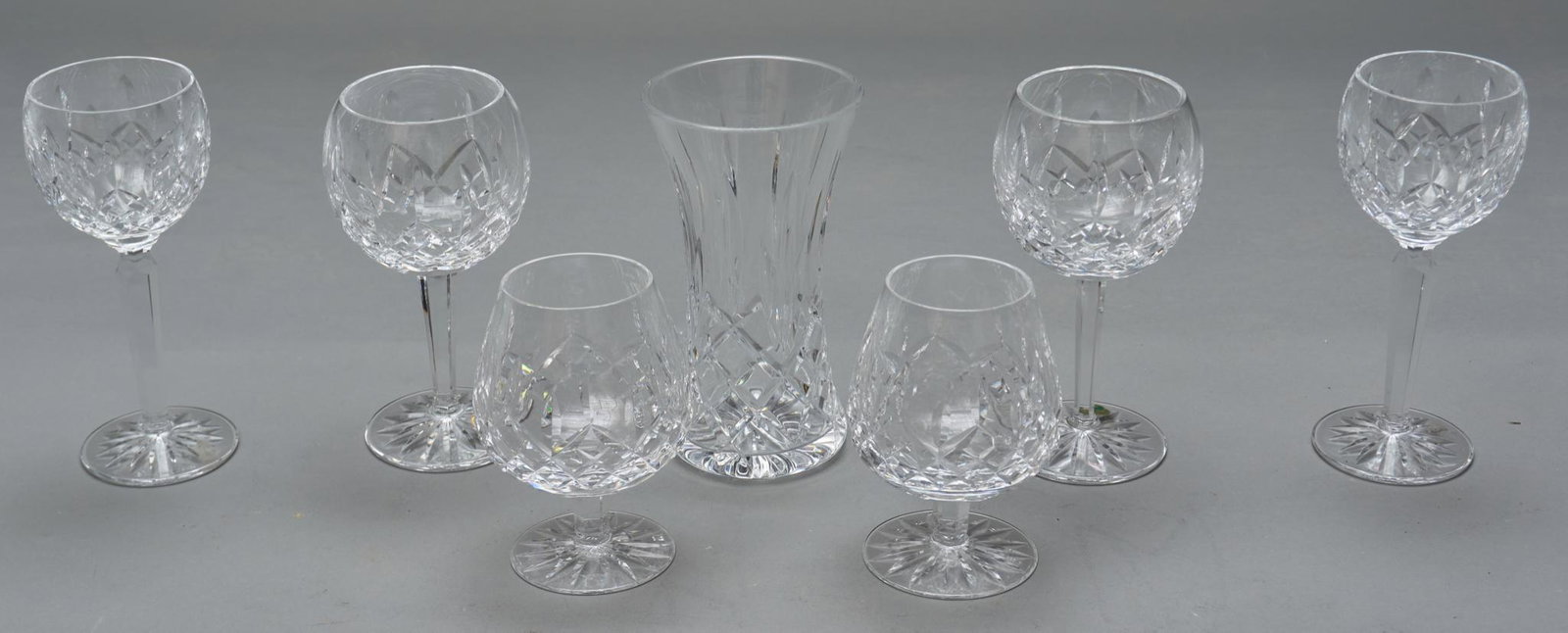 Collection of 7 Waterford Crystal: Collection of seven pieces of Waterford crystal, to include sherry glasses, wine glasses, vase, marked on base 7"h x 4"d/ largest We happily provide seamless shipping services on everything we