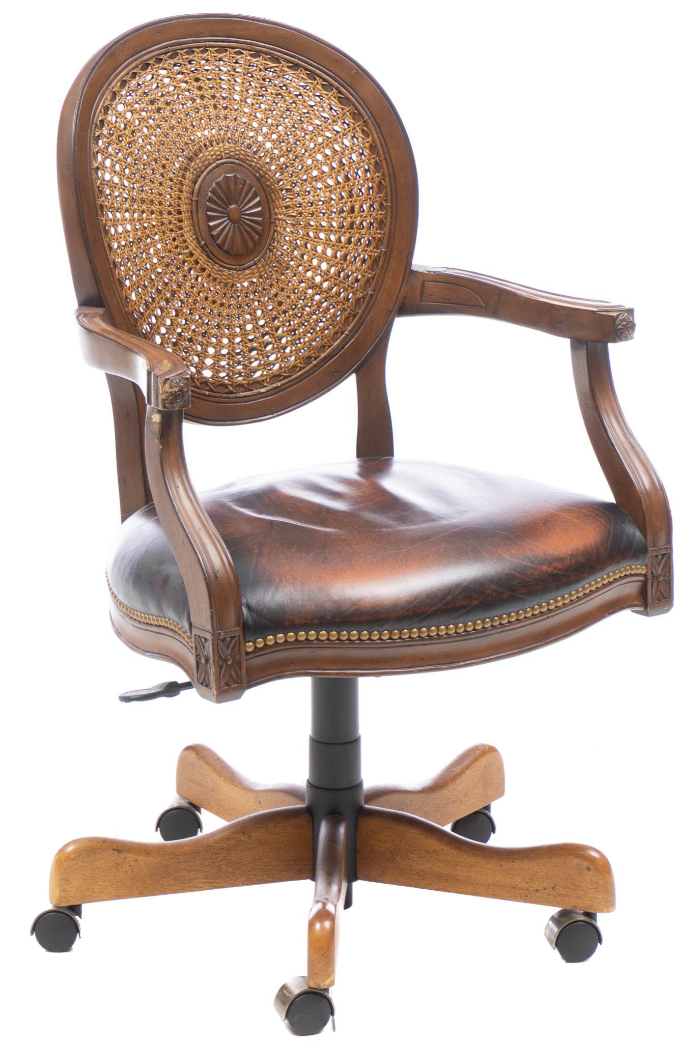 Cane Work Executive Chair: Executive chair, having cane work back with center embellishment, with brown leatherette seat, rising on pedestal swivel base with casters 40.5"h x 24.5"w x 26"d Provenance: A San Antonio,