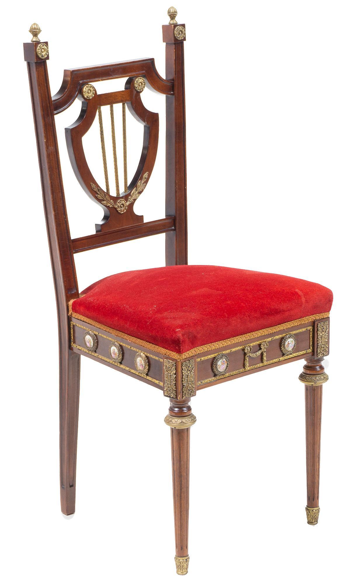 French Empire Style Velvet Chair: French Empire style red velvet chair, with cushioned seat and crest back, rising on turned legs with porcelain accents depicting classical courting scenes 38"h x 16"w x 15.5"d Provenance: A Stockdale,