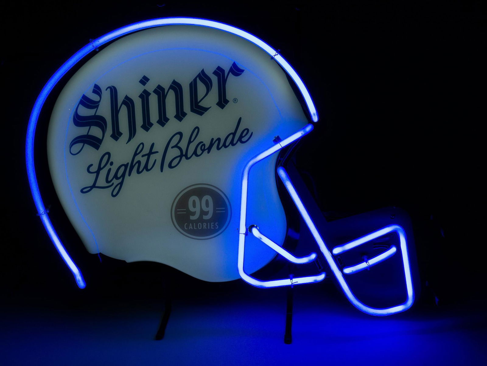 Vintage Shiner Light Blonde Neon Sign: Vintage Shiner Light Blonde beer neon bar advertising sign, featuring football helmet motif, "99 calories", blue stylized lettering, blue neon on metal frame, in working condition 21"h x 26.5"w x 6.5