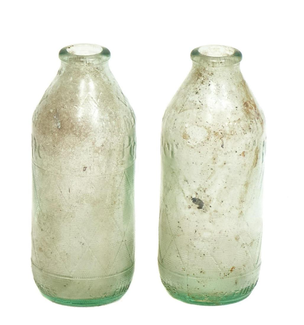 Pair of Early Dr. Pepper Glass Bottles: Pair of early Dr. Pepper glass bottles, green glass advertising with embossed accents, small neck and opening 5.5"h x 2"d/ each Provenance: The Estate of Glenn Terpin, San Antonio, Texas We happily