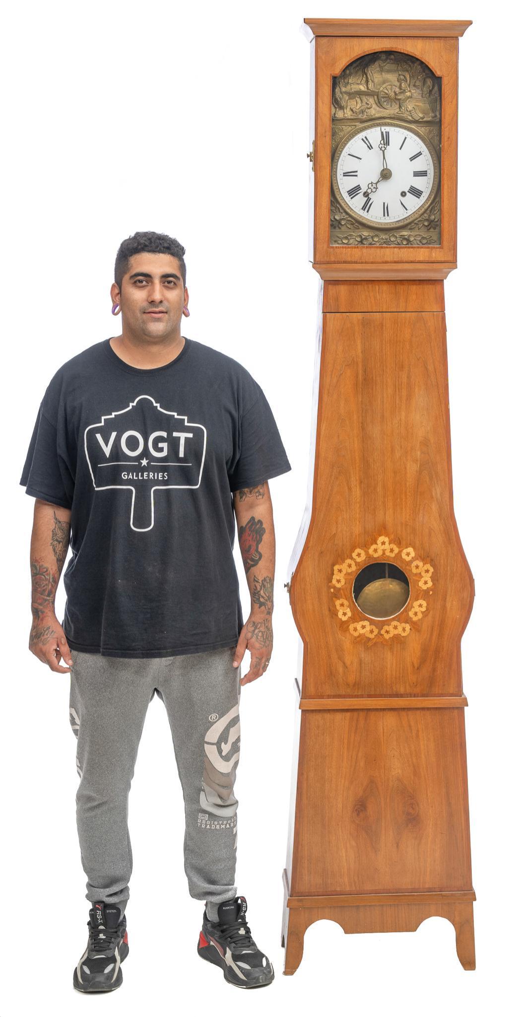 Morbier Tall Case Clock: Morbier clock, closed wooden encasement with molded and etched brass clock face and pendulum 93.5"h x 18.5"w x 9"d Provenance: A San Antonio, Texas collection We happily provide seamless shipping serv