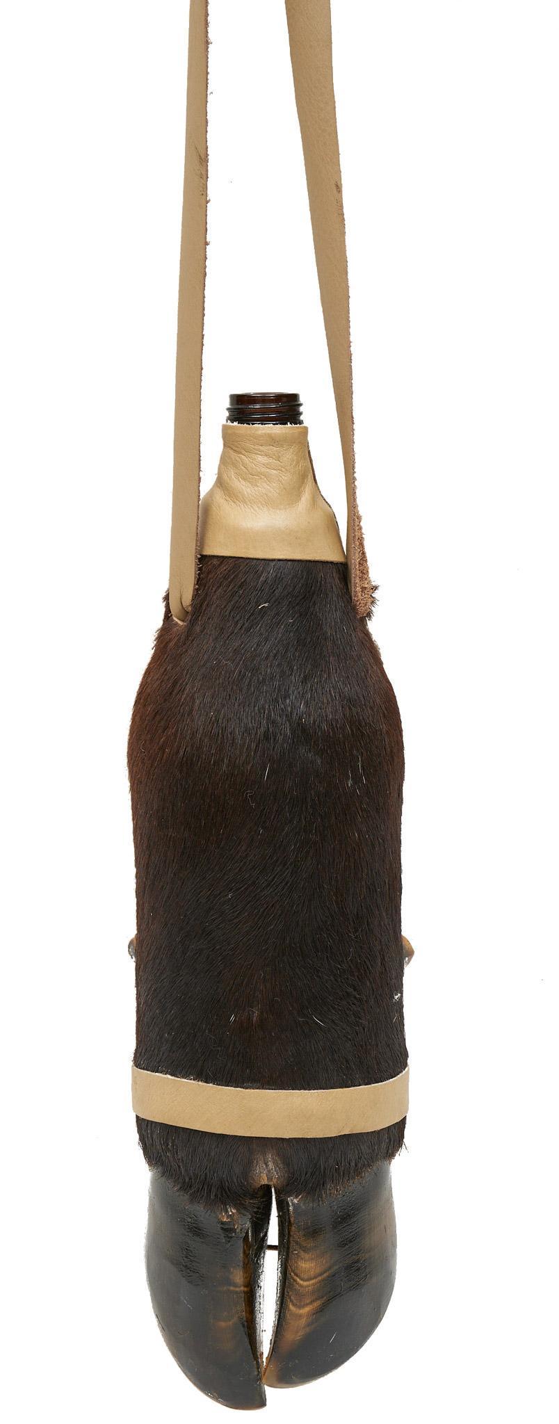 Taxidermy Hoof Bottle: Taxidermy hoof bottle, having a leather strap 15"h x 4.5"d Provenance: A Seminole, Texas collection We happily provide seamless shipping services on everything we sell. Please email us at shipping@vog