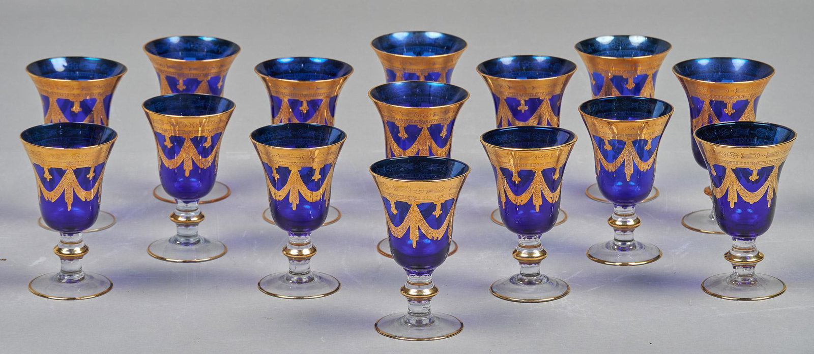 Set of (15) Interglass Cobalt Crystal Wine Goblets: Set of fifteen matching Interglass cobalt blue crystal wine goblets, featuring hand-decorated gold accents, to include seven small goblets and eight large, made in Italy 9"h x 3.5"d/ largest W