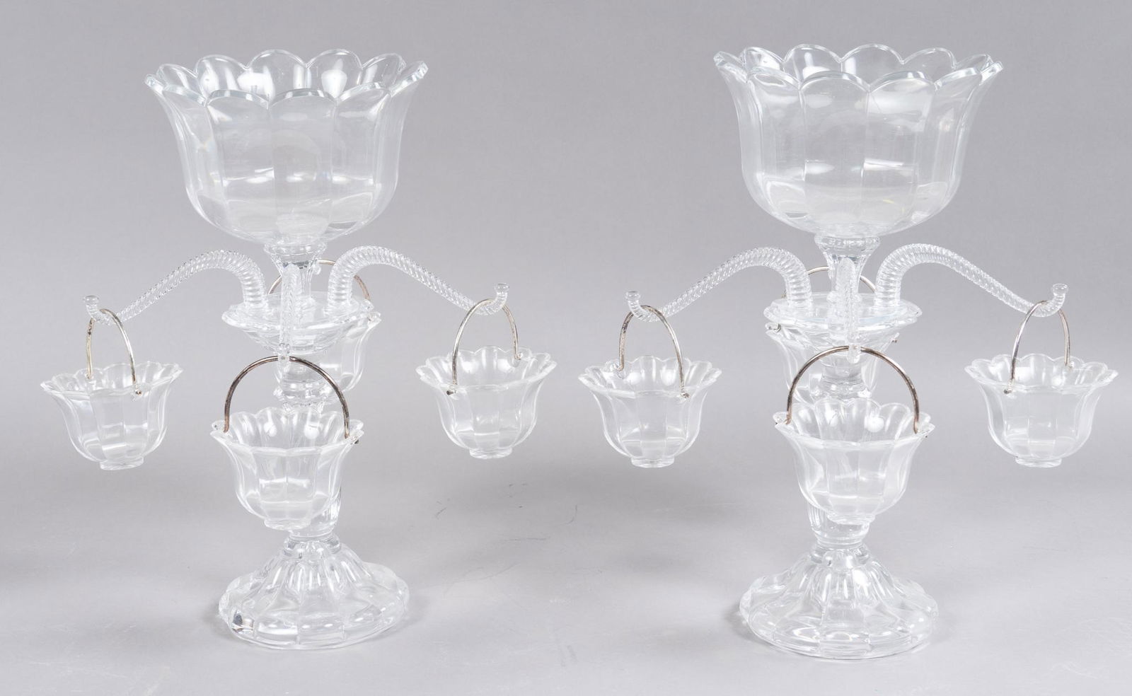Pair of Cut Glass Epergnes: Pair of glass epergnes, featuring fixed bowl. to include eight scalloped cups 18"h x 16"d/ each We happily provide seamless shipping services on everything we sell. Please email us at shippi