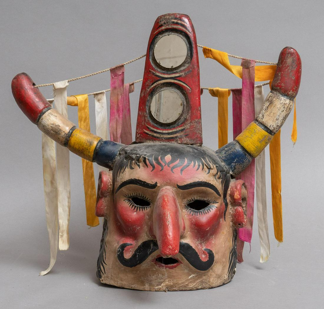20th C. Mexican Festival Mask: Mexican festival mask, featuring carved frame depicting a mustached man, with colorful ribbon and horns, with ears 19"h x 21"w Provenance: A San Antonio, Texas collection Please note: All the Mexican 