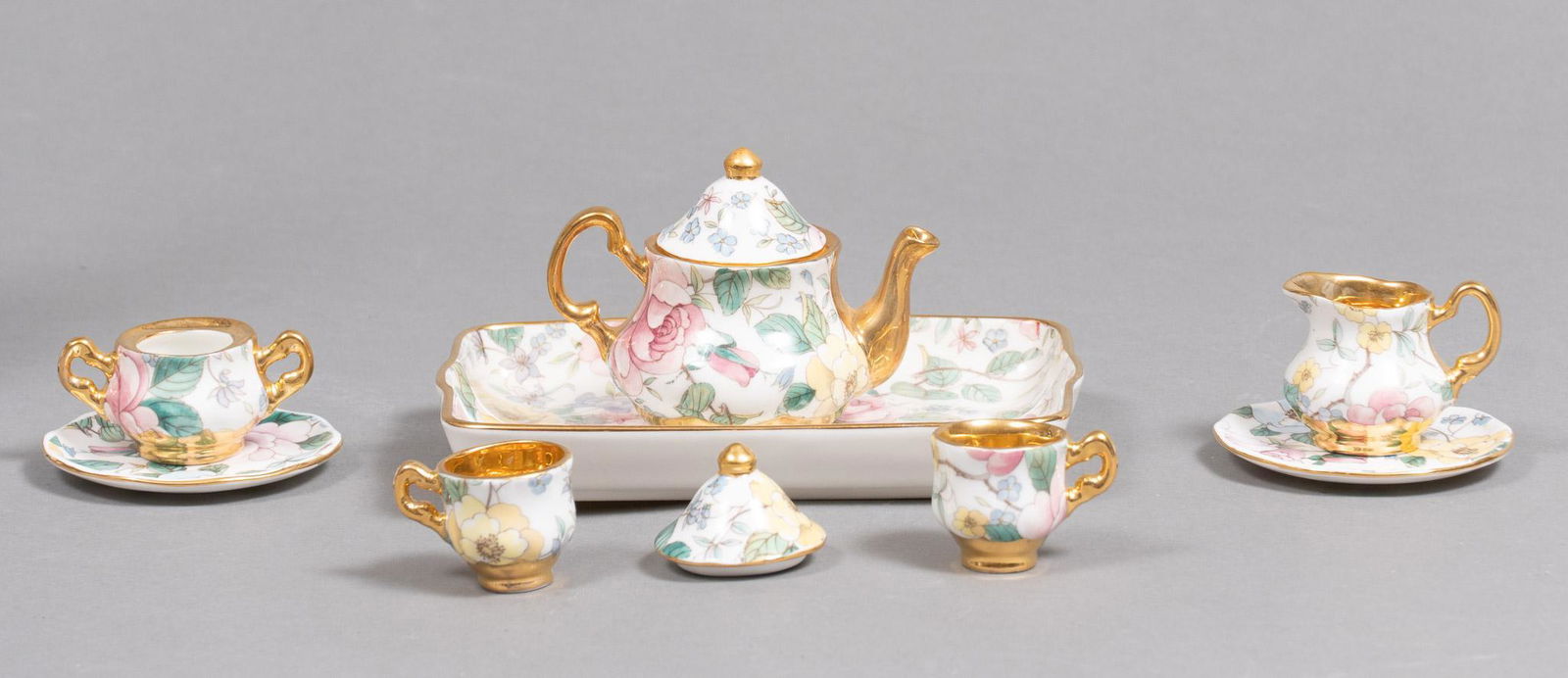 Raesuevic Ceramics Miniature Fine Bone China Tea Set: Raesuevic ceramics miniature fine bone china tea set, featuring hand-painted floral design with gilt accents 2 1/2"h x 4"w x 2"d Condition: missing piece Provenance: A prominent Terrell Hills, Texa