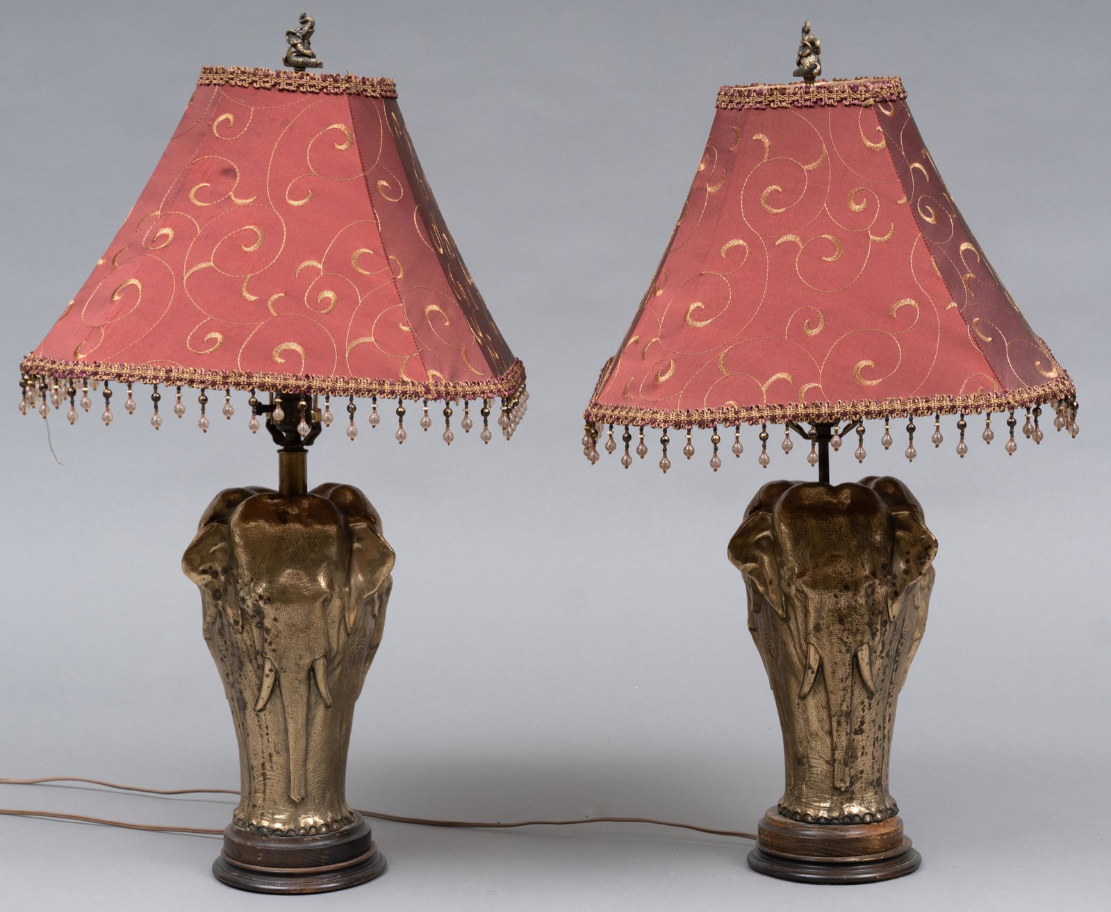 Pair of Matching Elephant Table Lamps: Pair of matching table lamps, having brass elephant bases supported on wooden bases, to include lamp shades, wiring in working condition 32"h x 18"d Provenance: A Waco, Texas collection We hap