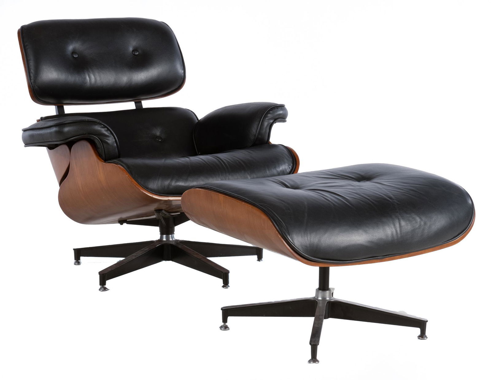 After Eames, Mid-Century Lounge Chair and Ottoman: Mid-century lounge chair and matching ottoman, after Eames design, having black leather upholstery, supported in curved wooden frame, rising on swivel base 31"h x 34"w x 27"d Condition: minor chips
