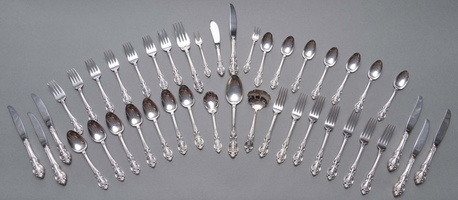 "Grand Victorian by Wallace Silversmiths Sterling Flatware Set: "Grand Baroque" by Wallace Silversmiths sterling silver flatware set 42pc; no monogram or removal Includes: 7 dinner knives 8 7/8" 7 dinner forks 7 5/8" 7 salad forks 7 teaspoons 7 oval soup spoons