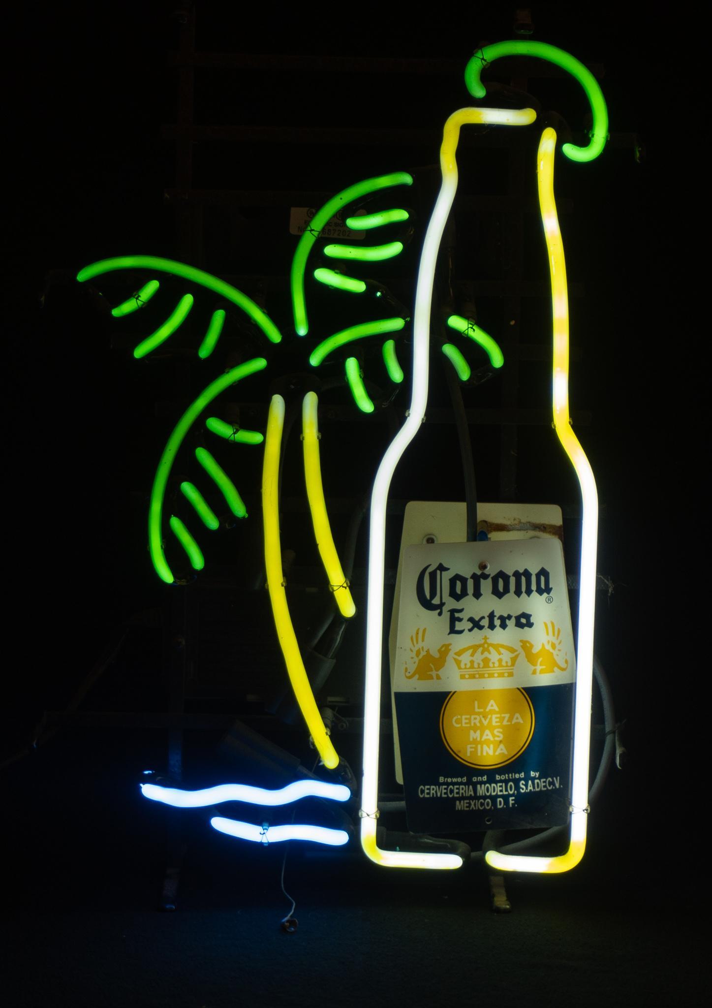 Corona Extra Neon Sign: Corona Extra neon sign, featuring beer bottle and palm tree design, supported on metal stand, in working condition 21.5"h x 13"w x 7"d Condition: Corona Extra label not attached Provenance: A Cany
