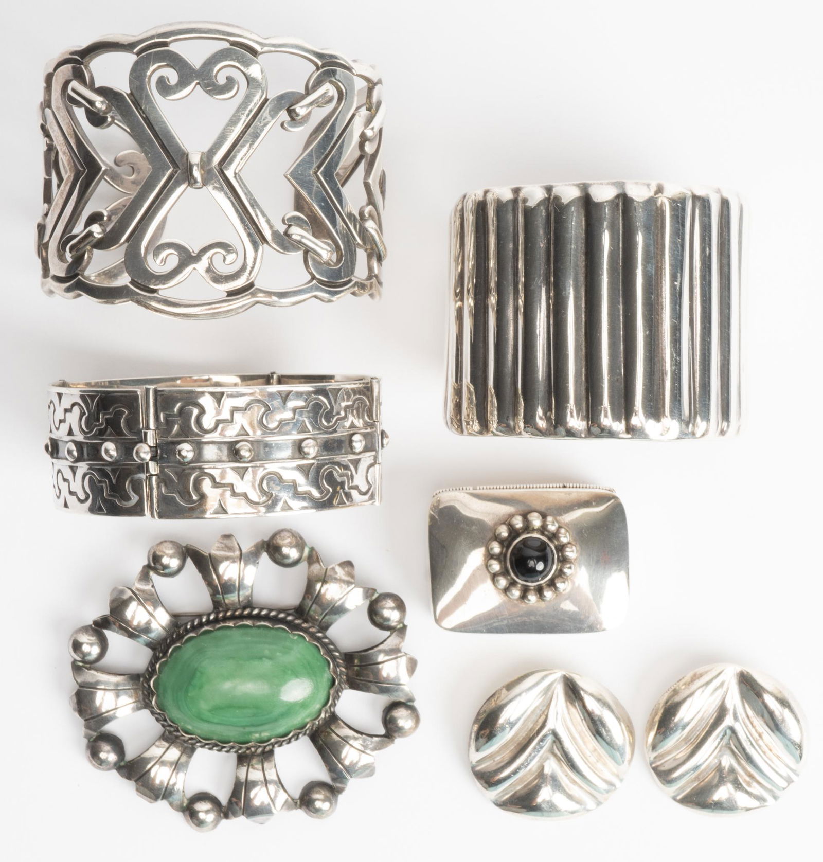 Collection Vintage Mexican Sterling Silver Jewelry: Collection of vintage Mexican sterling silver jewelry includes two cuff bracelets, linked panel bracelet, brooch, clip on earrings and pill box. Cuff 2 1/8" width, hinged bracelet 1" width;