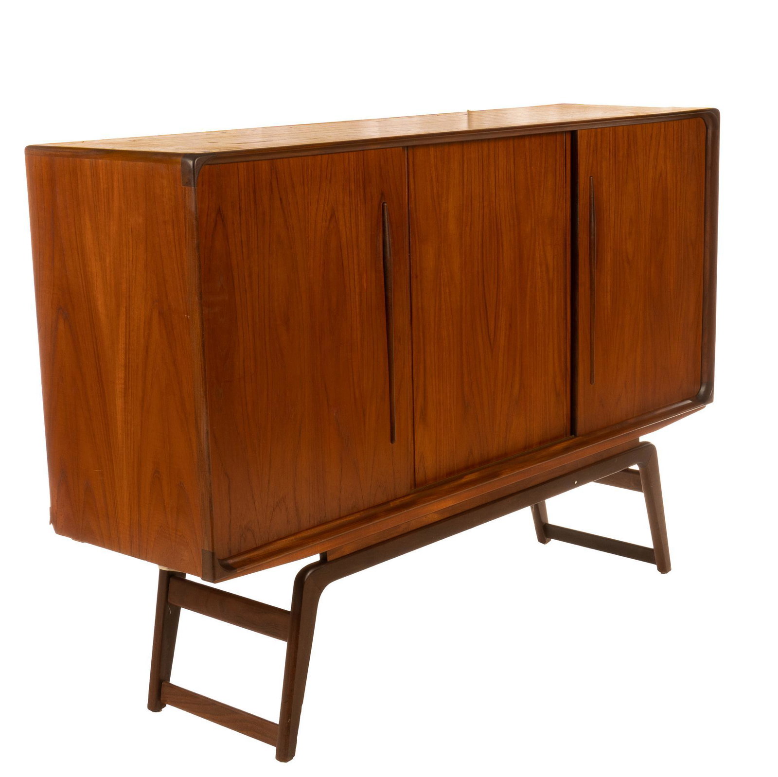 Danish Mid-Century Credenza: Danish Mid-Century teak credenza / sideboard, having sliding doors, opening to center storage shelves, flanked by flat drawers, rising on stretchered bracket legs 45.5"h x 67"w x 18.5"d We happily pro