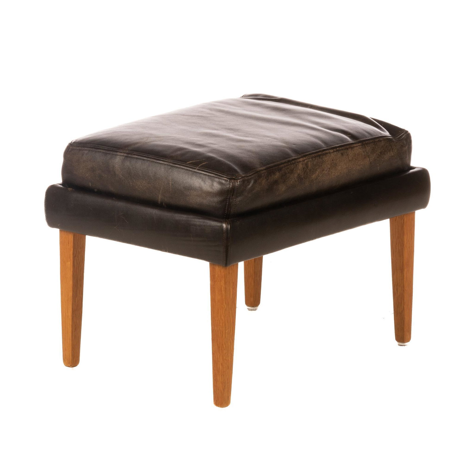 Danish Mid-Century Ottoman: Danish Mid-Century ottoman, having leather cushion top, supported on pin legs 17"h x 22.5"w x 17"d We happily provide seamless shipping services on everything we sell. Please email us at shipping@vogt
