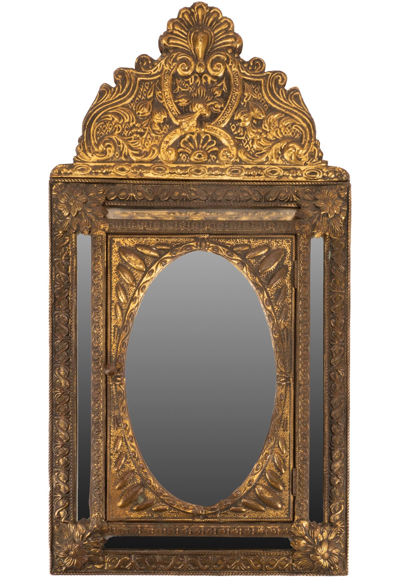 Antique Napoleon III Wall Mirror and Brush Box: Antique Napoleon III wall mirror, featuring intricate gilt repousse, oval mirror face, mounted on door opening to interior storage, housing two brushes, circa 19th century 26.5"h x 14"w x 3.5&