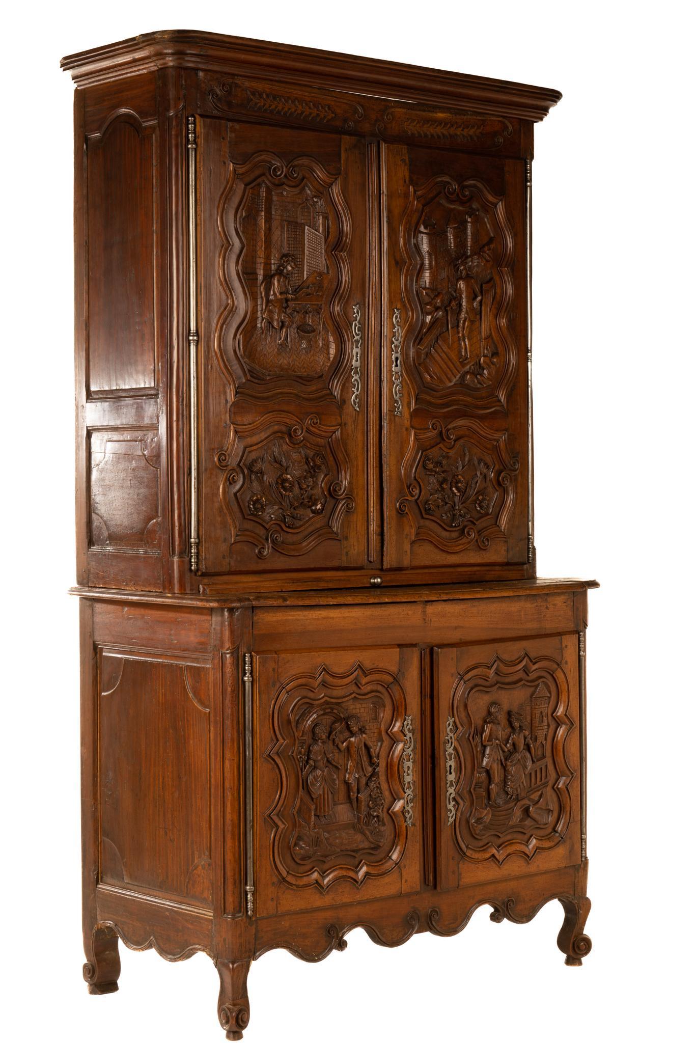 19th Century Louis XV Buffet: Louis XV fruitwood two-tier buffet, having two double cabinets leading to interior shelf storage, above carved serpentine apron, featuring heavily carved historic scenes and scroll motif, rising on ca