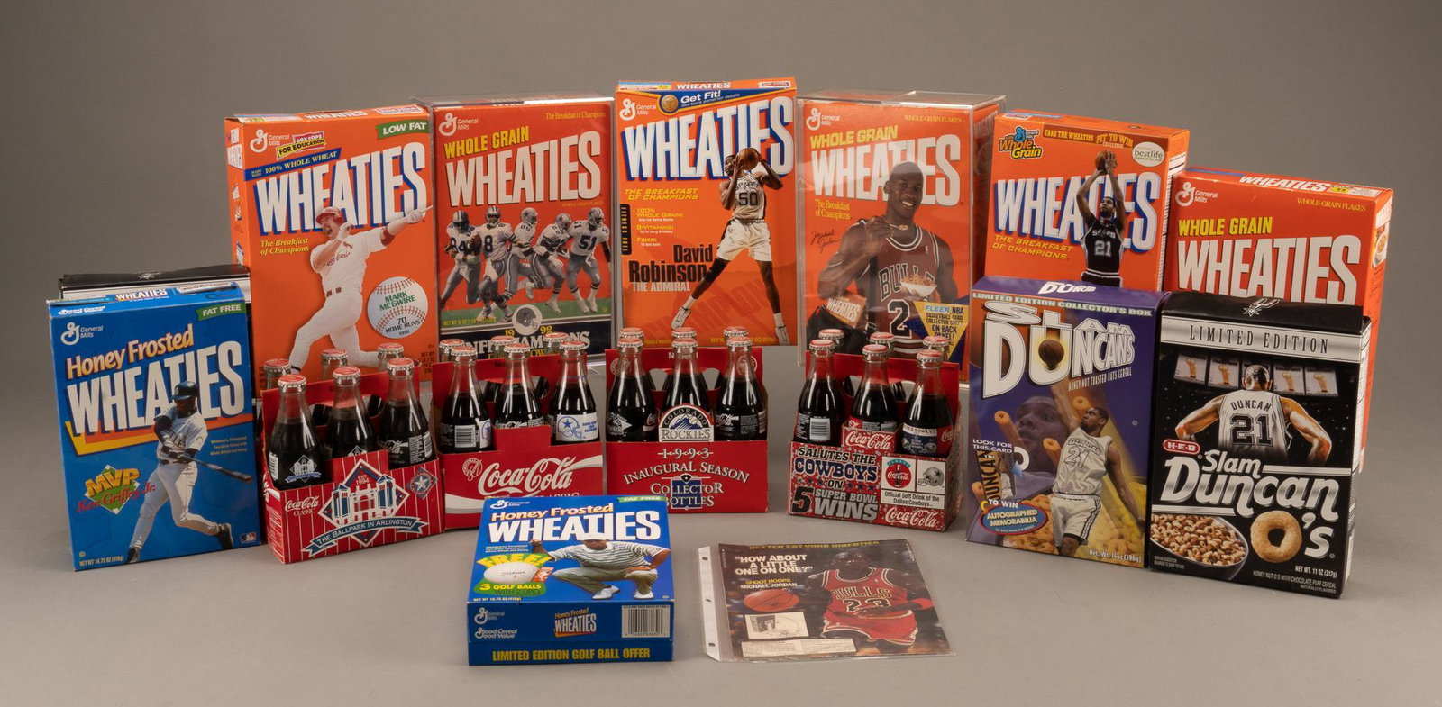 Collection of Coke Bottles and Wheaties Boxes featuring NFL, NBA and MLB teams: 8 Wheaties boxes featuring sports figures and teams, 2 boxes of Slam Duncan O's, and 4 6-packs of Coke featuring Dallas Cowboys, Texas Rangers and Colorado Rockies 13"h x 9"w x 4"d We 