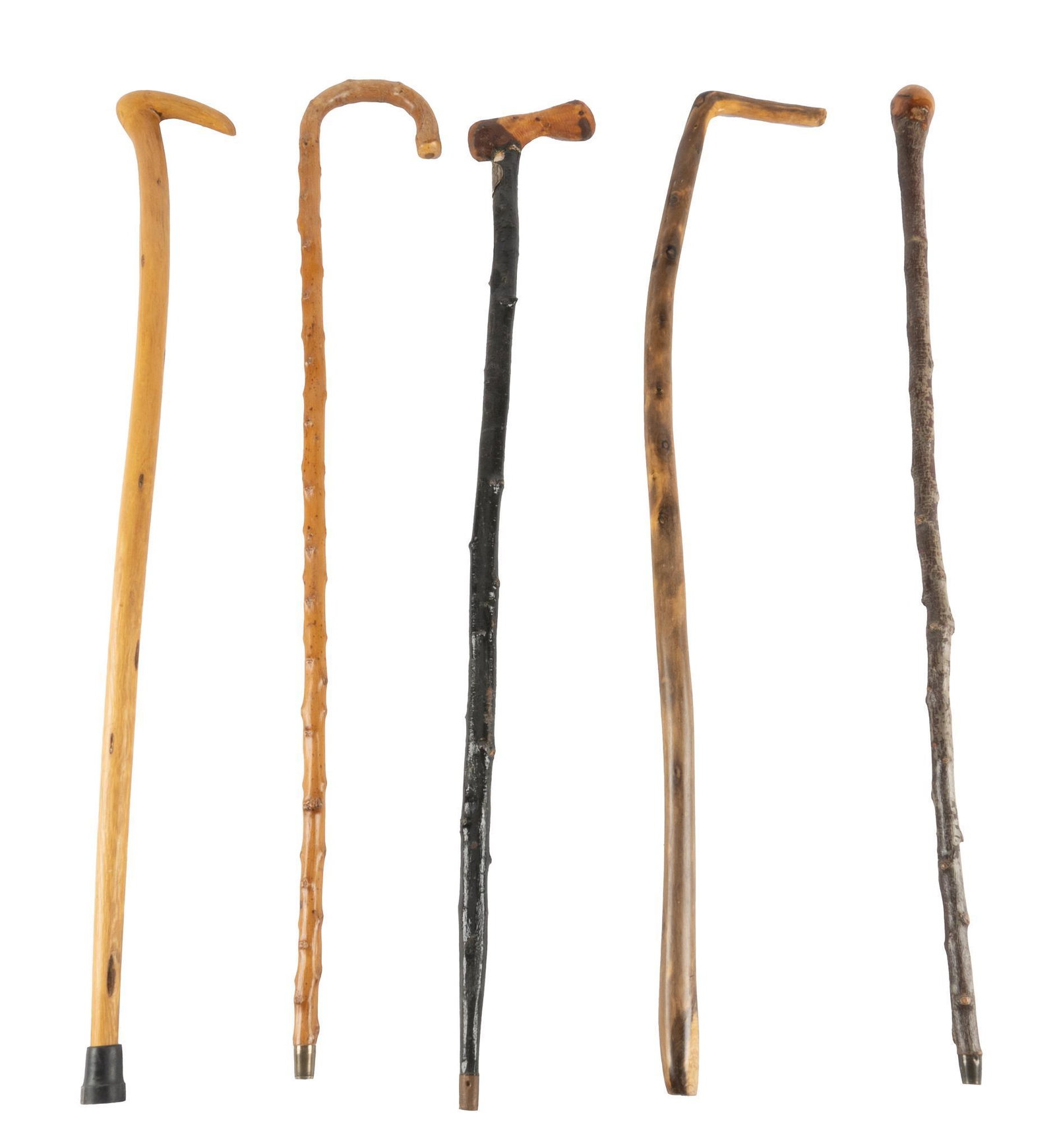 Set of (5) Walking Sticks: Set of five hand-carved walking sticks, tipped in metal and rubber, one marked with English coat of arms 40"h x 5"w x 1"d / tallest Provenance: The Estate of Ann Tobin (San Antonio, Texas)
