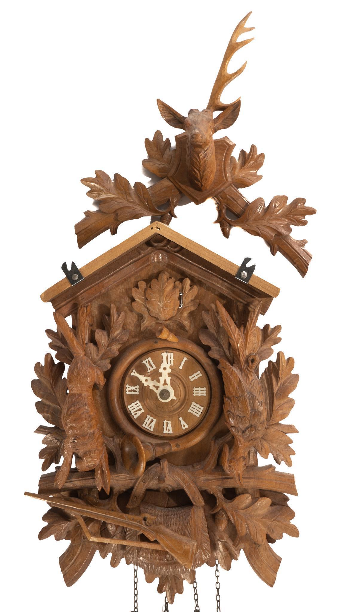 Black Forest Regula Cuckoo Clock: Black Forest Regula cuckoo clock, 30 hour, housed in carved wooden frame, topped deer head crest, above hunting motifs, such as wild game, rifle, etc. 11"h x 7" x 5.5"d €â€¹&eur