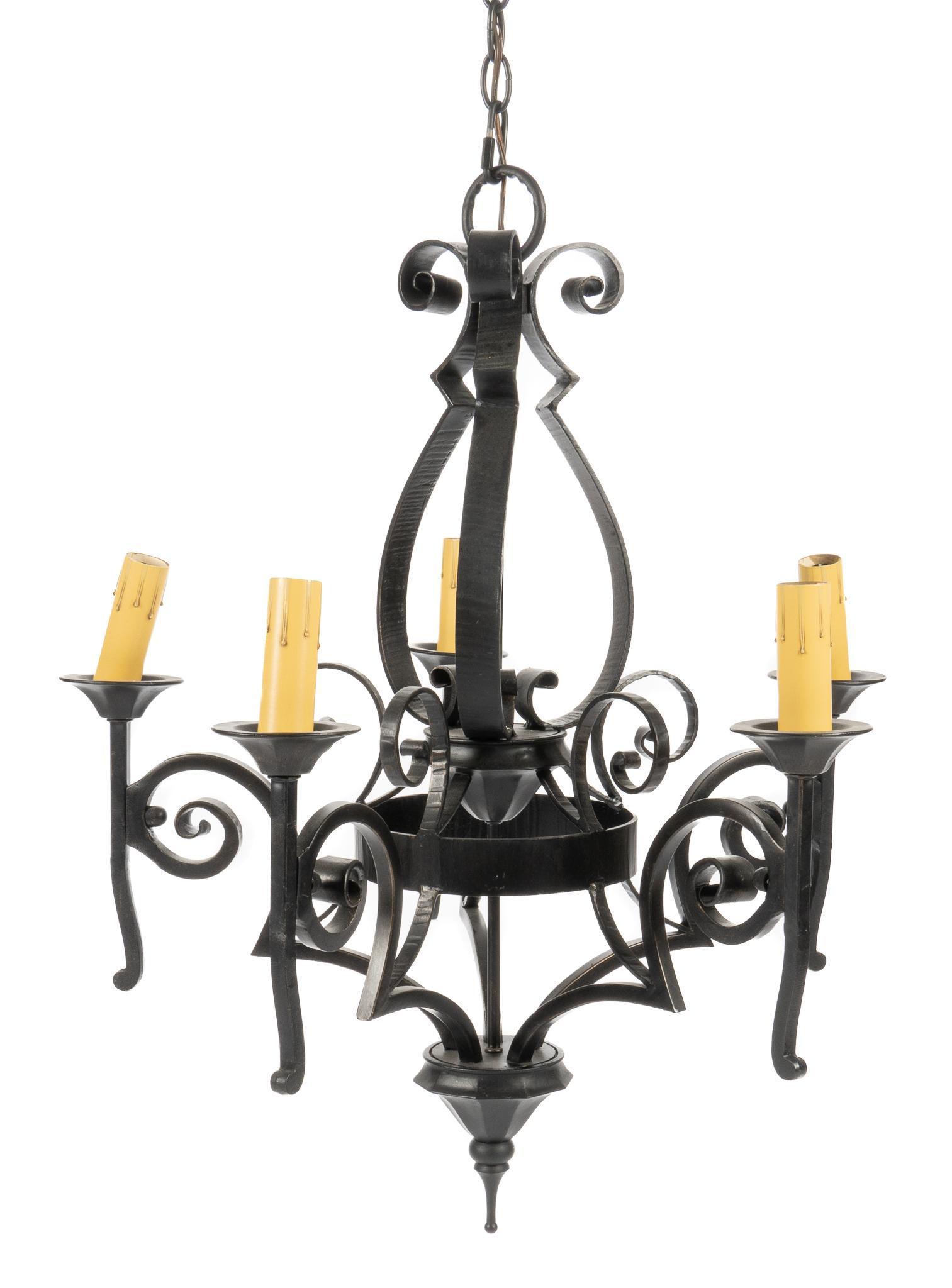 Four-Light Wrought Iron Chandelier: Wrought iron chandelier, with four scrolled arms, supporting faux candles, featuring pointed finial bottom height 31 in. x width 24 in. x depth 24 in. Provenance: An Alamo Heights, Texas collection We