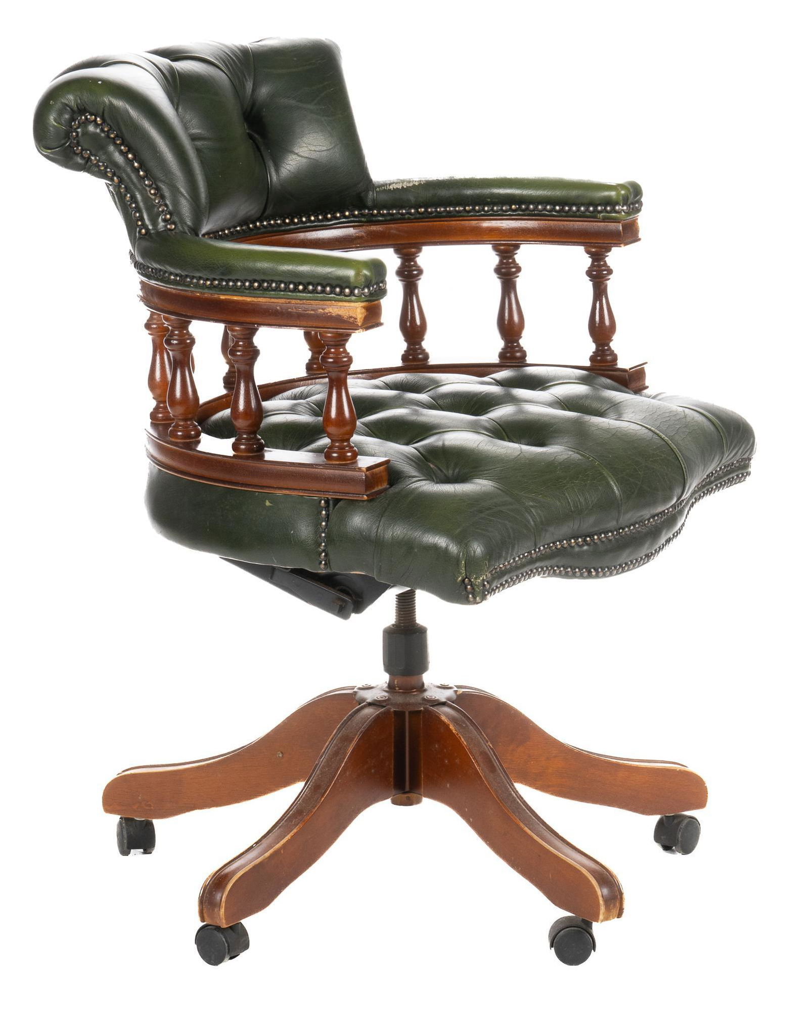 Vintage Chesterfield Captain's Desk Chair: Vintage Chesterfield captain's desk chair, having rounded back, with turned balustrades, featuring green tufted leather upholstery, metal stud accents, supported on swivel base, ending in casters