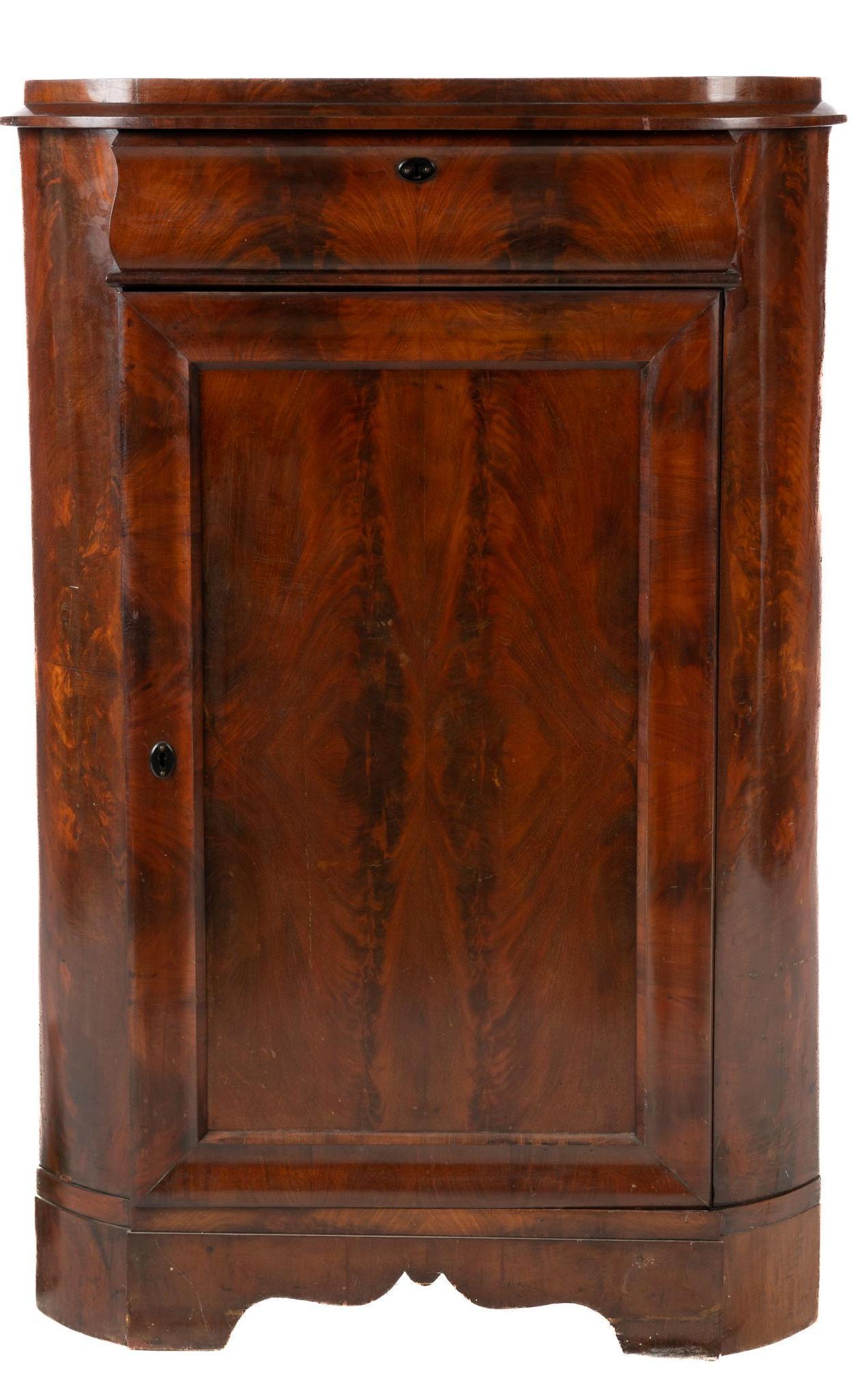 Corner Cabinet: Mahogany corner cabinet with a single door opening to interior with two removable shelves, a top drawer with dovetail construction, supported on ogee bracket and block feet, to include one key height 