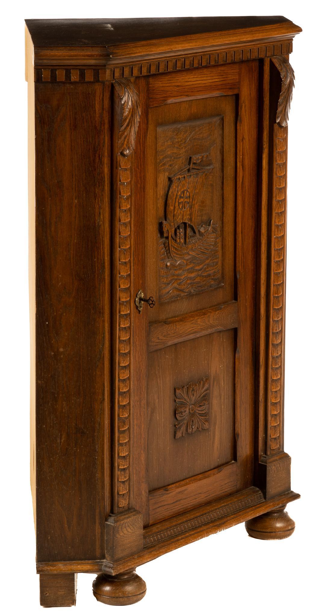 Danish Corner Cabinet: Corner cabinet, made in Denmark, having a single door with a carved scene of a Viking ship opening to a three shelf interior, supported on bun feet and block feet, stamped on back, to include one key 