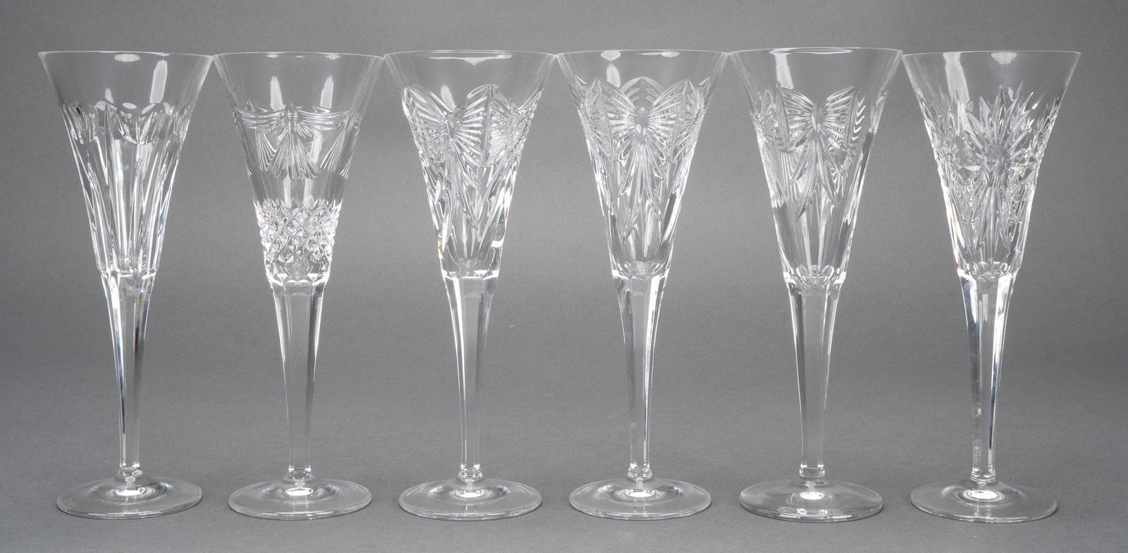 Waterford Crystal Fluted Champagne Glasses: Six (6) champagne toasting glasses from Waterford Crystal of various motifs including Love, Happiness, Prosperity and Health. Height 9 1/4 in. Provenance: a San Antonio, Texas collection We happily pr