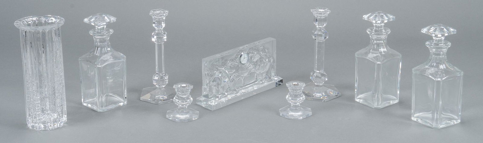 Collection of Crystal Table Ware: Collection includes three Baccarat decanters, candles sticks, elephant clock, Hadeland art glass vase and Val St Lambert candlesticks. Vase height 10 1/4 in., decanters 9 1/2 in. Provenance: Propert