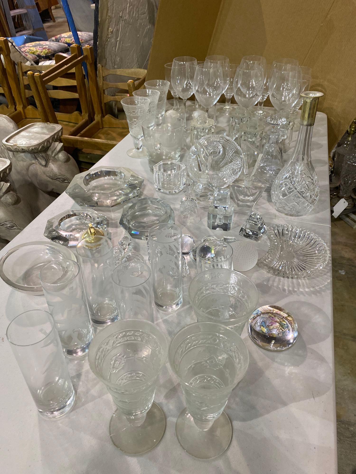 Lot of (51) Pieces of Glassware: Lot of fifty-one pieces of glassware, to include wine glasses, perfume decanters, ashtrays, etc. height 12 in. x diameter 4.5 in. / tallest We happily provide seamless shipping services on everything 