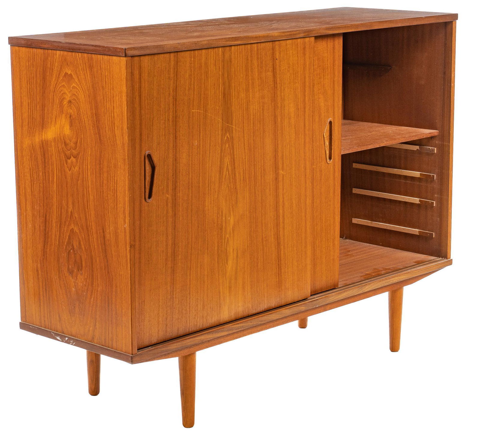 Mid-Century Cocktail Cabinet: Mid-Century teak cocktail cabinet, with sliding doors with recessed pulls, opening to interior mirror backed compartment above storage niche, beside shelved storage, supported on pin legs height 50.5