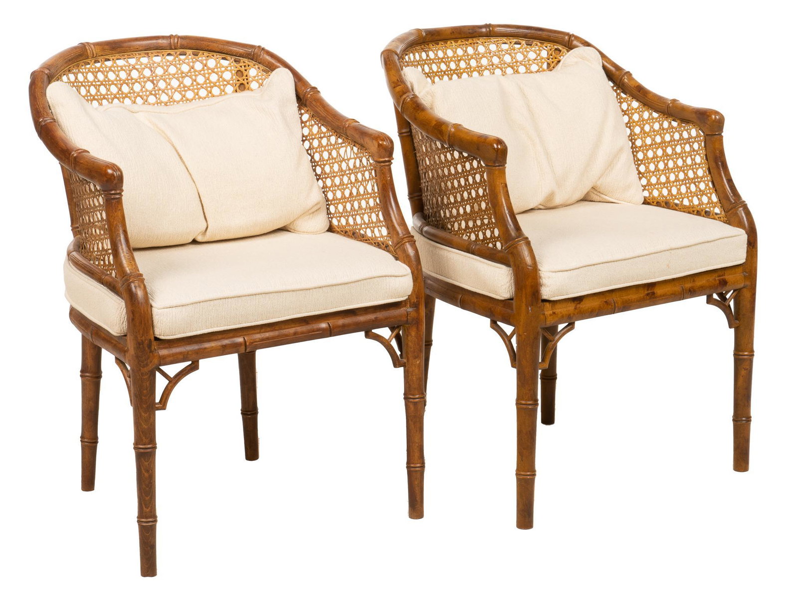 Pair of Cane and Bamboo Lounge Chairs: Pair of lounge chairs, with frames carved to look like bamboo, featuring cane works back, with removable seat and back cushions height 32 in. x width 23 in. x depth 25 in. / each Provenance: Property 