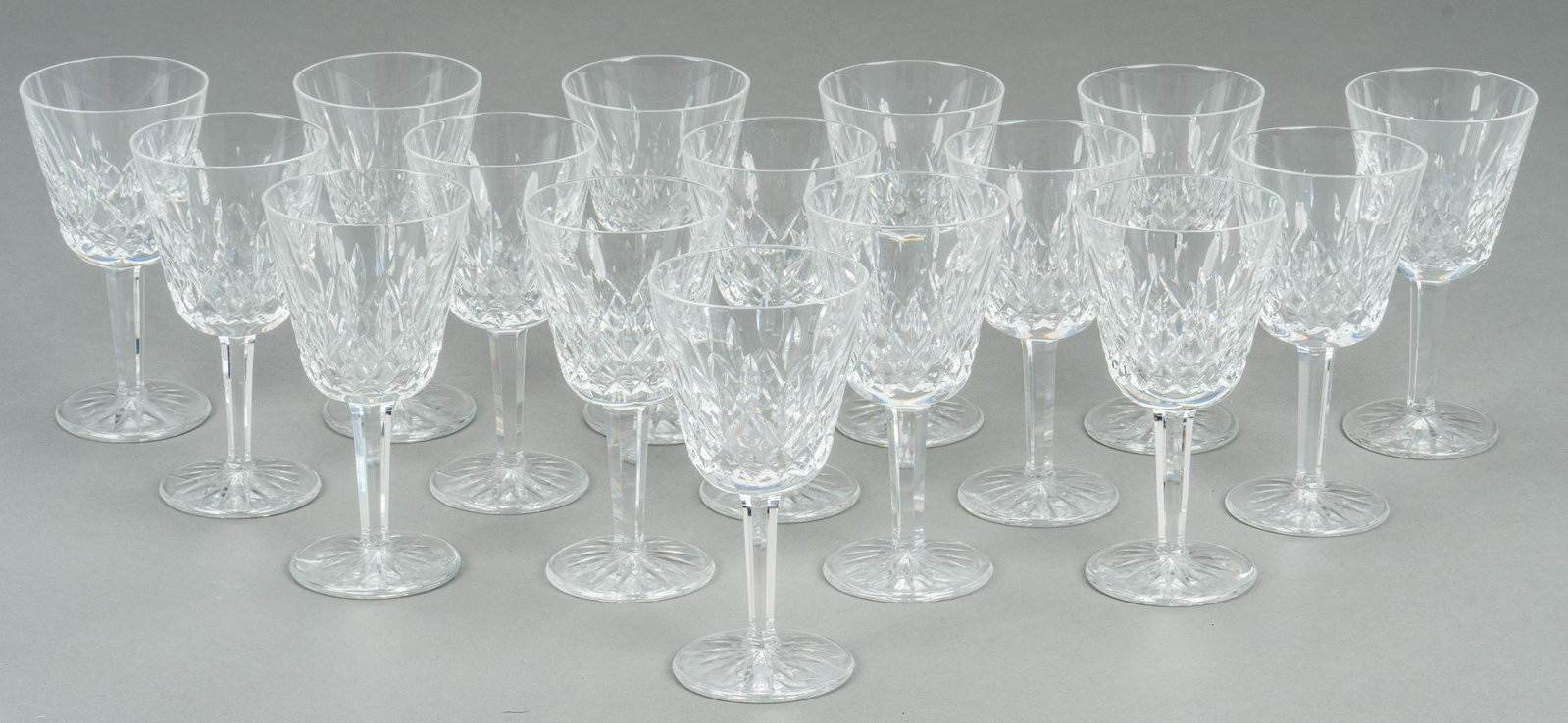 Waterford "Lismore" White Wine Glasses: Sixteen (16) white wine goblets in the "Lismore" pattern from Waterford Crystal. Height 5 3/4 in. Provenance: A New Braunfels, Texas collection We happily provide seamless shipping services on