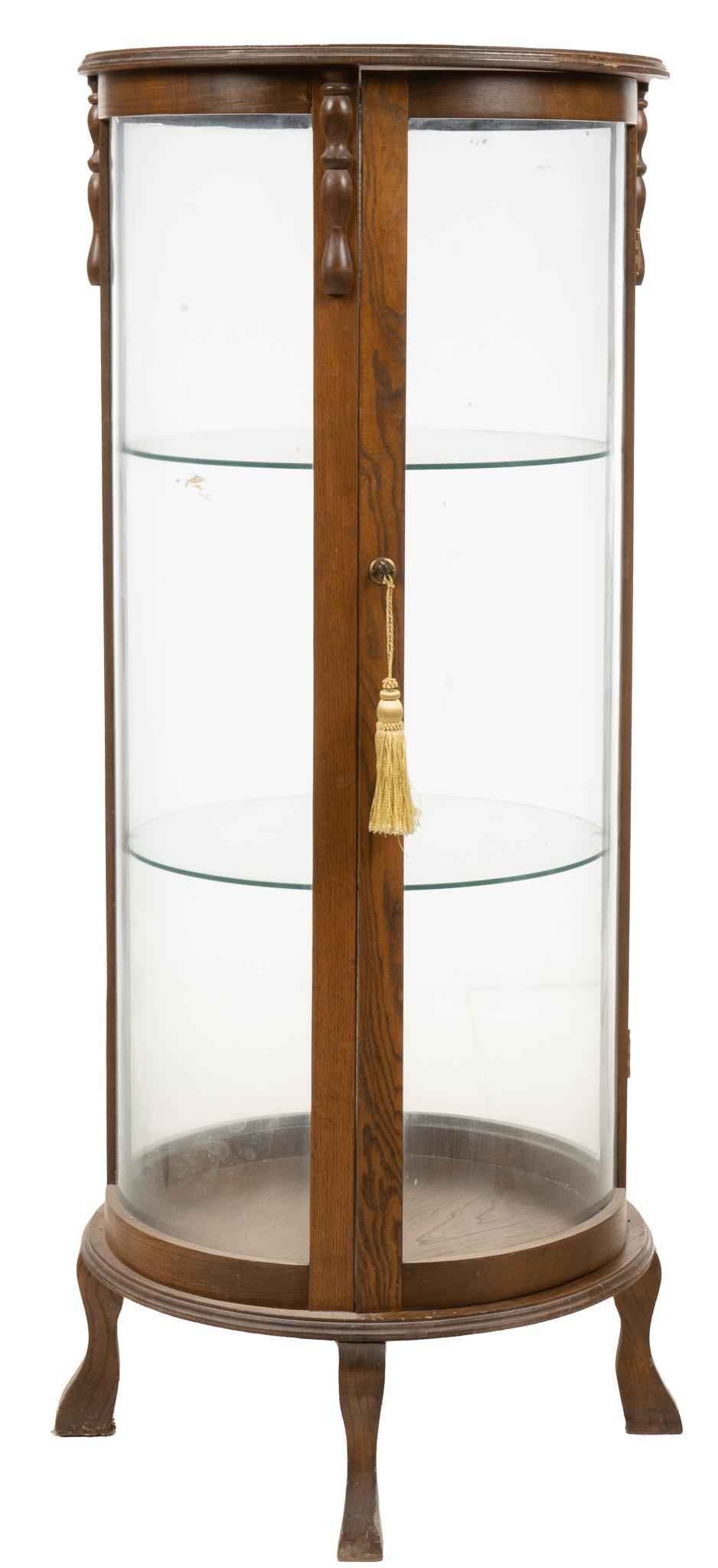 Vintage Curio Cabinet: Vintage circular curio cabinet, with oak frame, three glass sides and glass inset door opening to interior with two glass shelves, supported on cabriole legs, with key height 56.5 in. x width 26 in. x