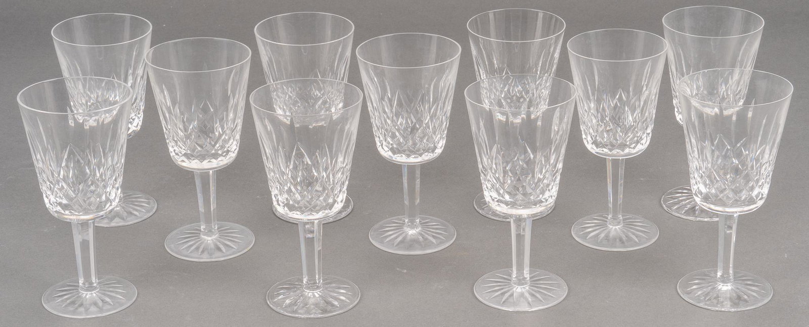 Waterford Crystal "Lismore" Red Wine Water Glasses: Eleven (11) red wine or water goblets in the "Lismore" pattern from Waterford Crystal. Height 6 7/8 in. Provenance: The Estate of Connie B. Poole, San Antonio, Texas We happily provide seamles