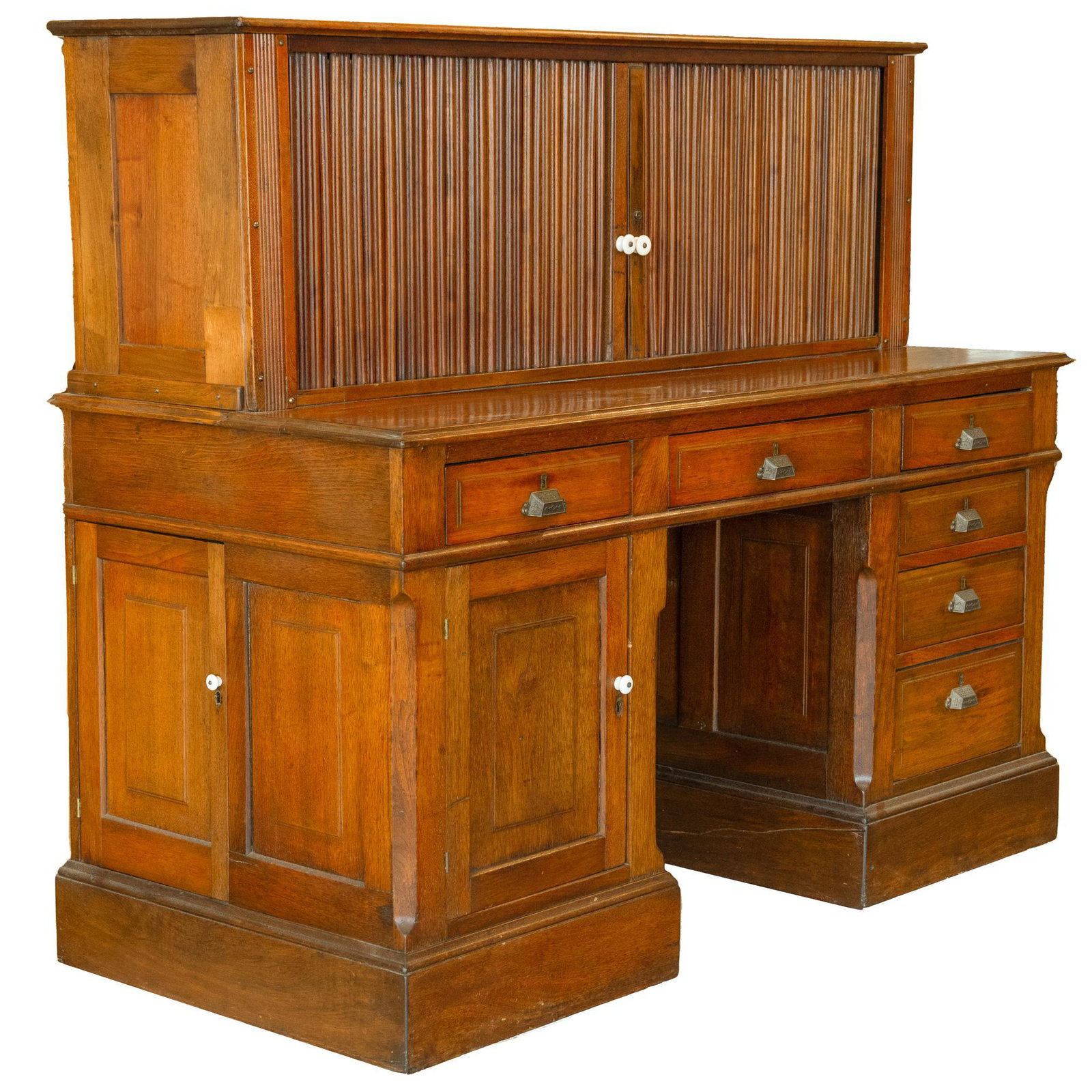Larry McMurtry's Vintage Pedestal Desk: Larry McMurtry's vintage pedestal desk, with tambour doors, opening to flat shelves, flanked by pigeon holes, over central drawer, supported on pedestal bases, one side with four stacked drawers, the 