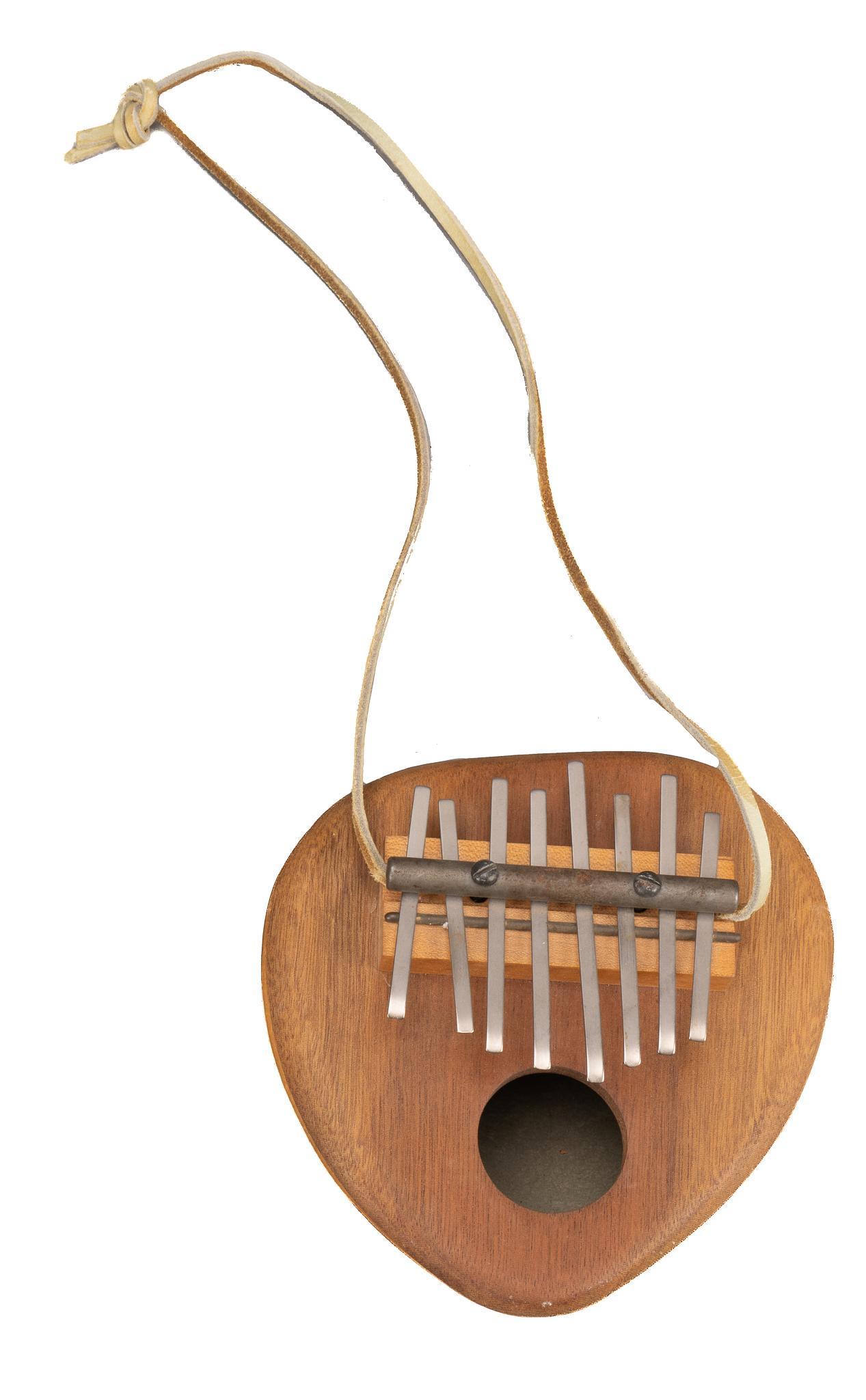 Eight Key Kalimba: Eight key kalimba / thumb piano, with hollowed gourd body, wooden front, with leather strap; includes Certificate of Authenticity: Estate of author Larry McMurtry, from his Archer City, Texas home hei