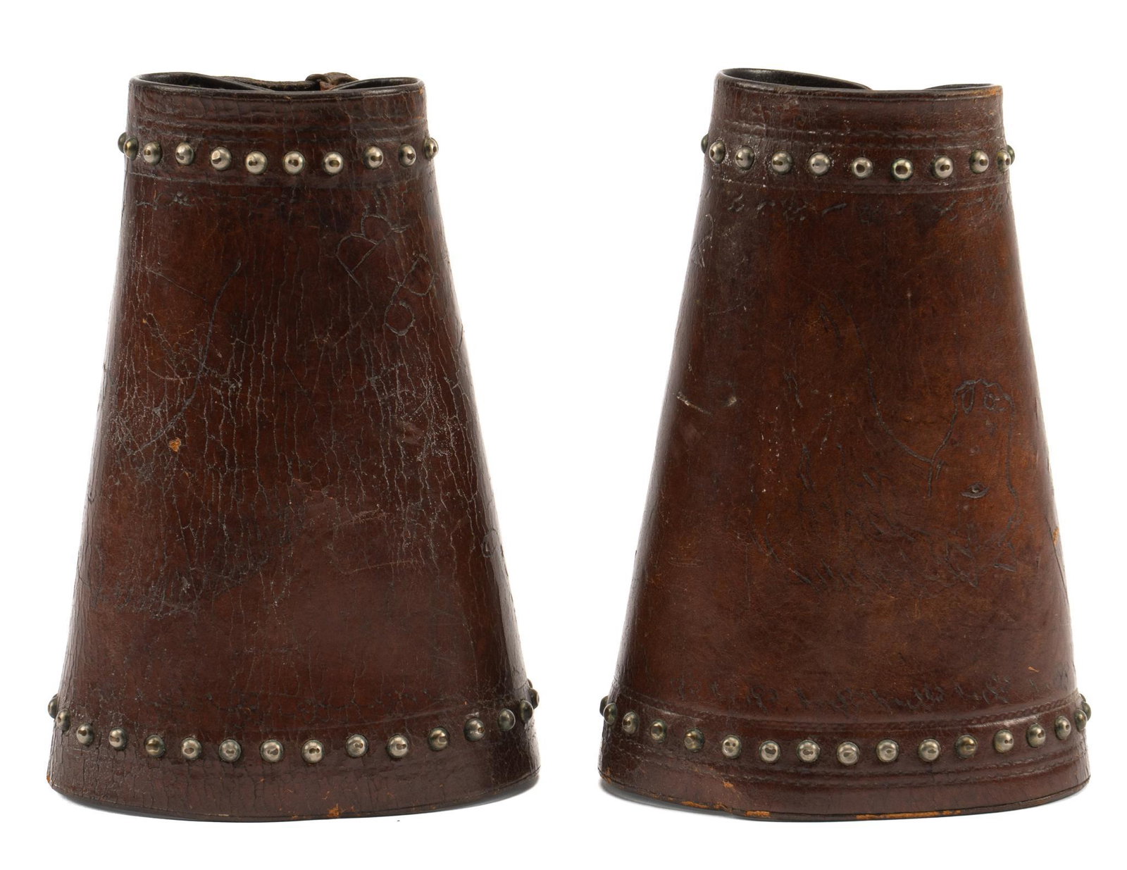 Pair of M.L. Leddy Marked Cowboy Cuffs: Pair of brown leather cowboy cuffs, with M.L Leddy mark "Leddy's", tooled borders, metal studs, each engraved with an image of a horse, a horseshoe, the initial "J.B." length 7.75 