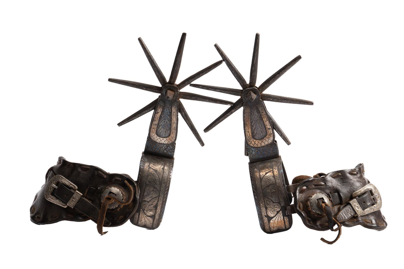 Massive Inlaid Silver Mexican Spurs: Massive Mexican spurs, with two inch steel heel bands, featuring inlaid silver floral motifs, engraved accents, large eight spoke rowels, period leather heel straps, with conchos and buckles heel band