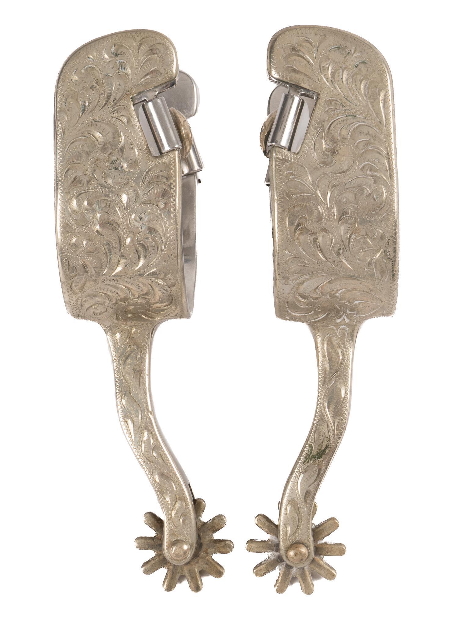 Silver Mounted Spurs: Silver mounted spurs, with steel heel band, featuring silver mounting, with engraved and etched scrollwork, ten point rowels heel band width 3 in. x spur length 6.5 in. Provenance: An Estero, Florida 