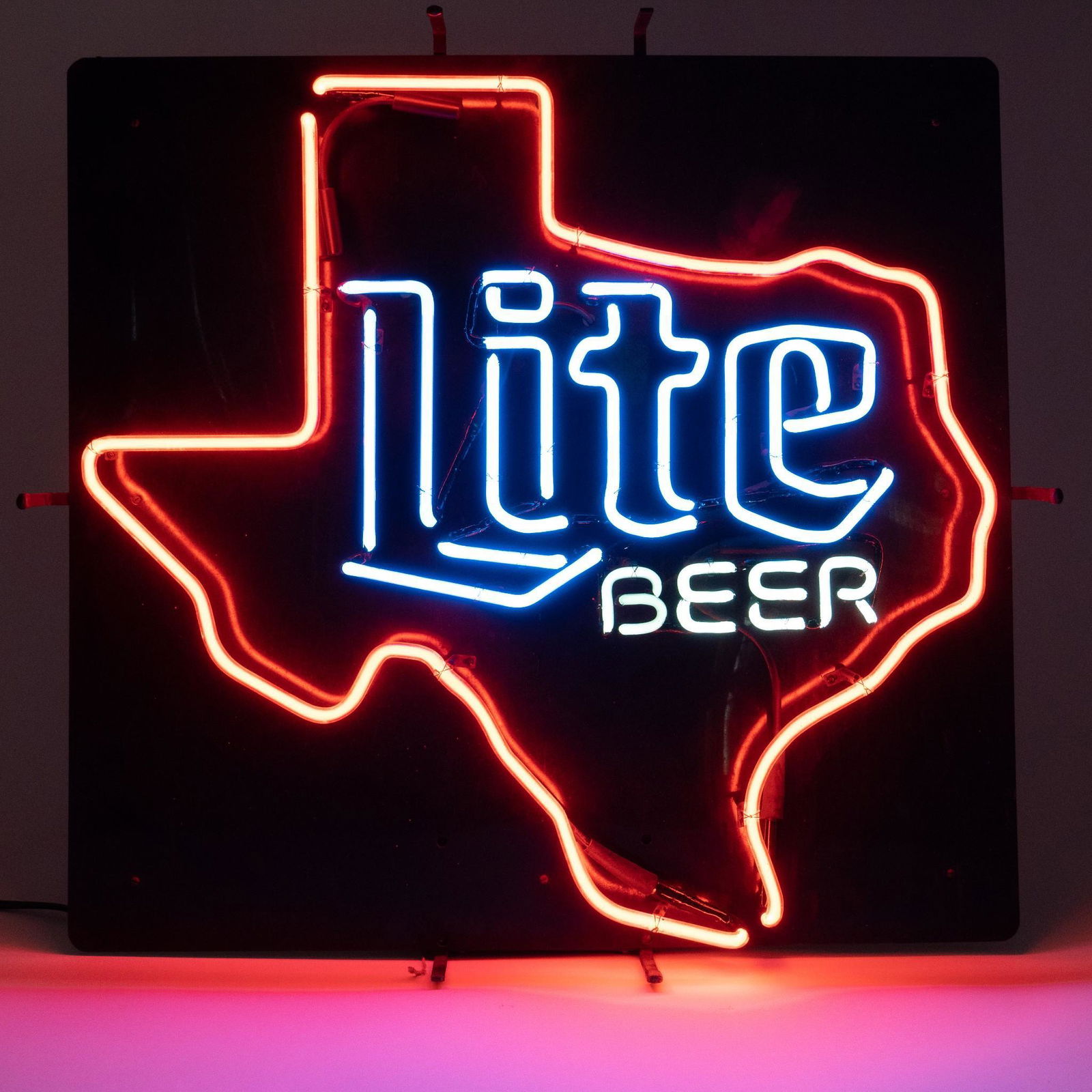 Texas Miller Lite Beer Neon Sign: Miller Lite Beer neon advertising bar sign, featuring red Texas border, framing blue and white script reading "Lite / Beer", on black metal backing, supported on metal frame height 27.5 in. x