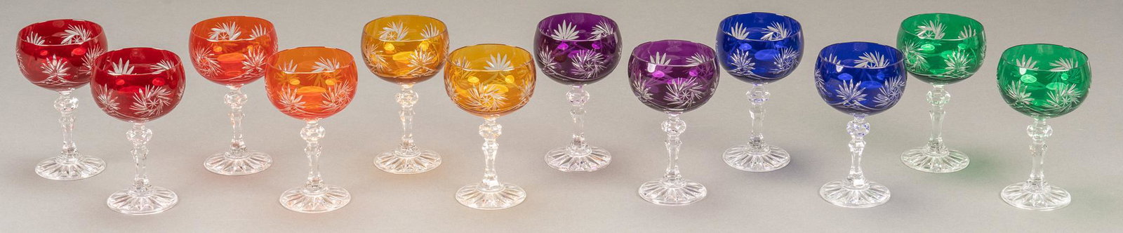 Set of (12) Cut to Clear Wine Glasses: Set of twelve cut to clear wine glasses, with colors purple, blue, red, orange, yellow, green, with "olive grinder" pattern height 6 in. x diameter 3.5 in. / each We happily provide seamless s